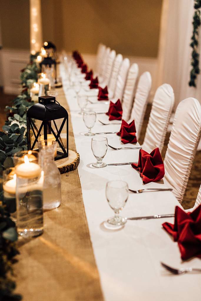 Reception table decorated in white, red and a burlap runner