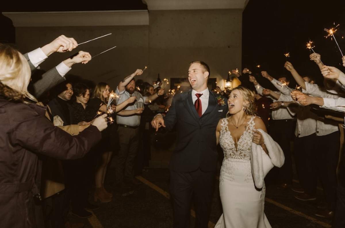 Couple At Their Wedding surrounded by people with sparklers